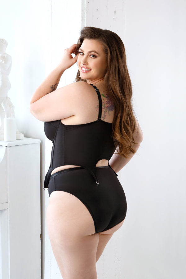Model wearing plus size black bustier lingerie by CT Lingerie shown from back with garter straps and high waist briefs