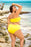 Linnea reversable plus size bikini swimsuit in bright yellow, modeled outdoors by a woman