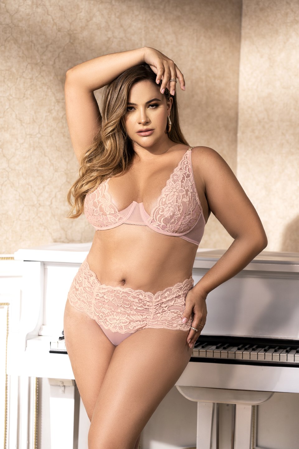 CT Lingerie model wearing blush pink lace bra and high waist panties posing by piano plus size lingerie