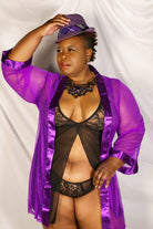 CT Lingerie model wearing purple sheer sexy satin trim robe over black lace lingerie and purple fedora
